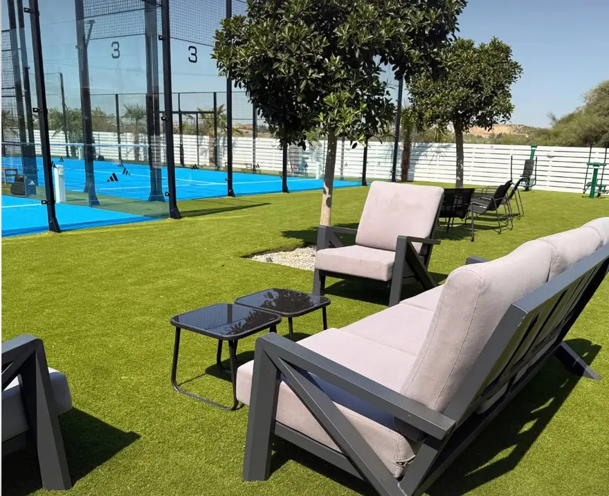 Lounge chairs on the grass beside the courts